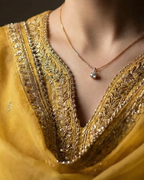 Yellow traditional outfit with intricate detailing on a dark background